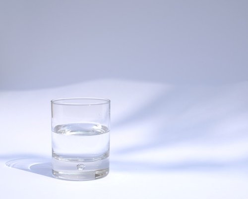 A glass of water near a window with sunlight shining through
