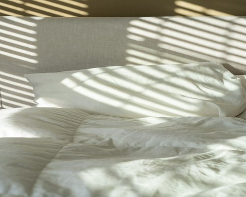 A comfortable pillow on a bed with soft lighting