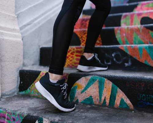 Feet in sneakers walking up outdoor stairs